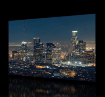 Blurred tall buildings at night in the city on a TV screen.